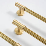 "Close-up of sleek brass pull bars with grooved detailing, showcasing a sophisticated and timeless design."
