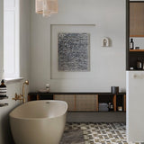 "A gray, contemporary wall lamp with a looped design, mounted on a white wall in a modern bathroom setting."