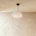 Cream cloud-shaped pendant light hanging above kitchen island with green cabinetry in modern home interior.