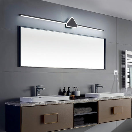 "A modern black wall lamp with a geometric centerpiece and streamlined bar, mounted above a large rectangular mirror in a contemporary bathroom with dual sinks."