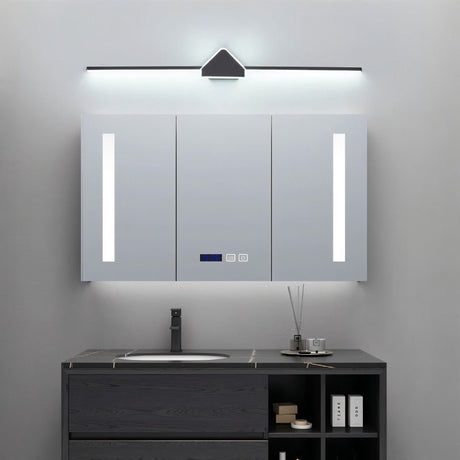 "A modern black and white wall lamp with a geometric centerpiece and streamlined bar, mounted above a mirrored medicine cabinet in a contemporary bathroom with a dark gray vanity."