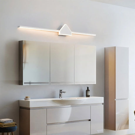 "A modern white wall lamp with a geometric centerpiece and streamlined bar, mounted above a bathroom vanity mirror in a contemporary bathroom with white cabinets."