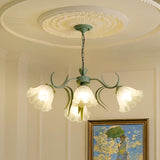 "A floral chandelier with curved arms and frosted glass shades resembling blooming flowers, hanging from a decorative ceiling medallion."