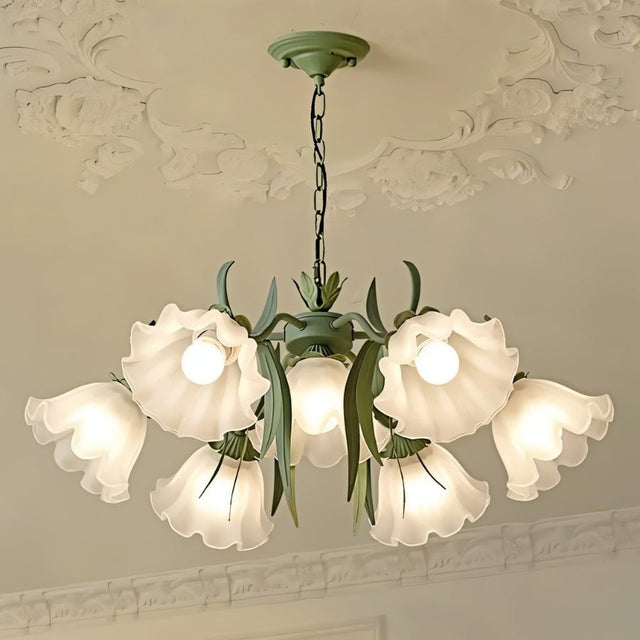 "Close-up of a floral chandelier with curved arms and frosted glass shades, hanging from a decorative white ceiling."