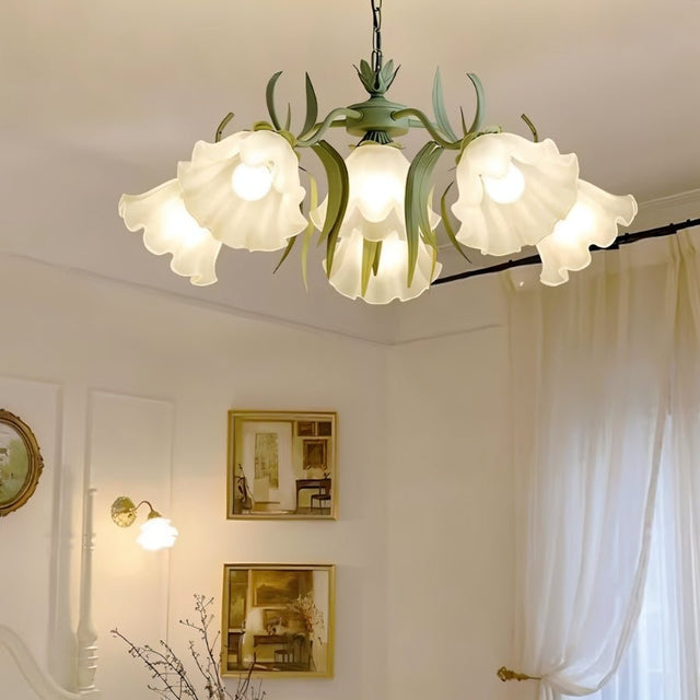 "A close-up of a floral chandelier with curved iron stems and frosted glass flower shades, showcasing its intricate details."