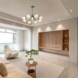 "A floral chandelier with curved iron stems and frosted glass flower shades illuminating a modern living room."