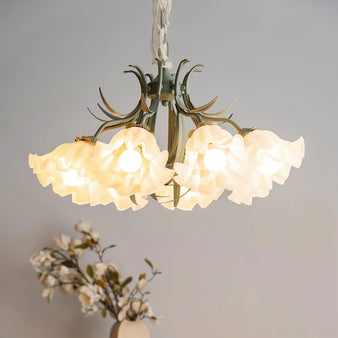 "A nature-inspired chandelier with curved iron stems and frosted glass shades shaped like blooming flowers, emitting a warm light."