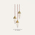 Three cone-shaped pendant lights with white marble bodies and brass tops suspended by burgundy cords against a neutral background.