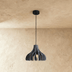Three green ribbed pendant lights with warm glowing bulbs suspended from ceiling against white wall and desk setup with plant