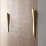"Two sleek, tapered zinc alloy pull bars with a geometric profile in a gold finish on a modern wooden cabinet."