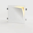 "A square white trimless wall light with a curved design, casting a warm glow from the recessed edge."