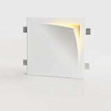 "A square white trimless wall light with a curved design, casting a warm glow from the recessed edge."
