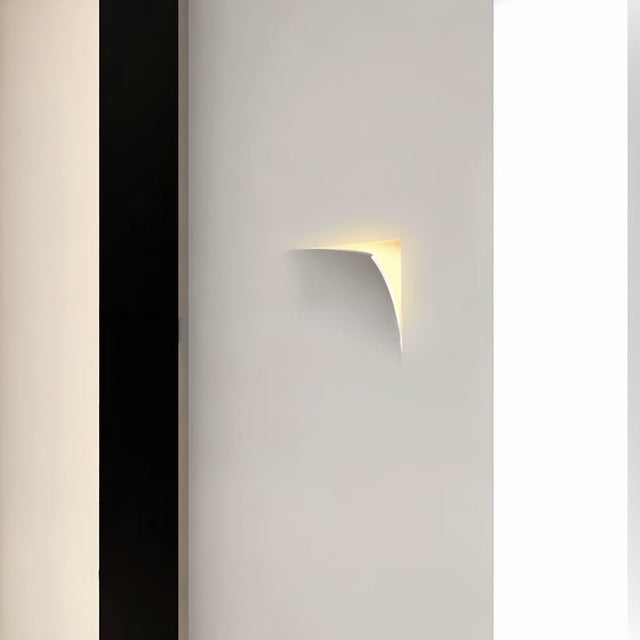 "A recessed trimless wall light casting a warm glow from a corner in a modern interior setting."