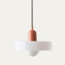 Pendant light with terracotta and white ceramic shade suspended from black cord against neutral background.