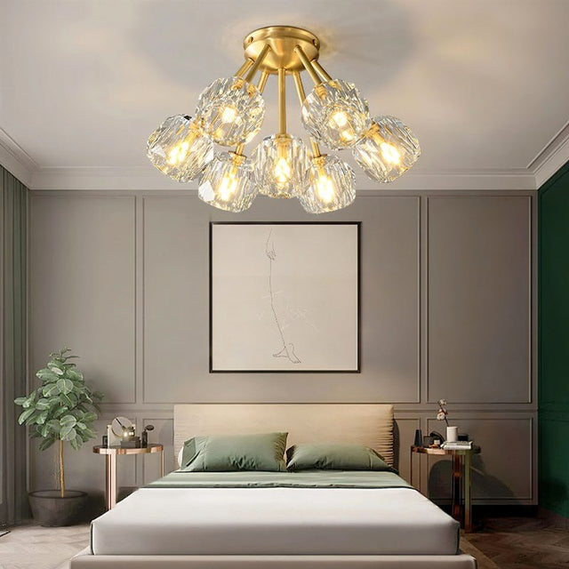 "Modern crystal ceiling light with brass finish illuminating a stylish bedroom."
