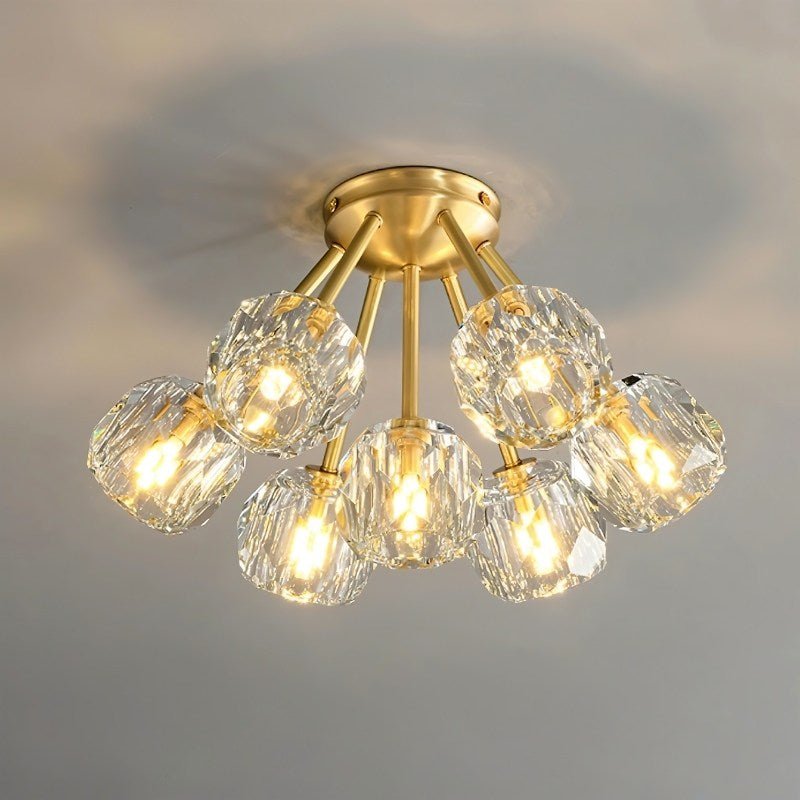 "Modern ceiling light with multiple crystal shades and brass arms, providing elegant ambient lighting."