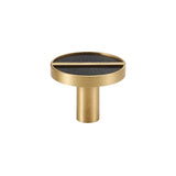 "Circular brass knob with a black leather inlay and a central brass bar."