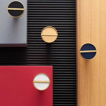 "Circular brass and leather cabinet knobs in various colors, combining modern luxury with classic craftsmanship."