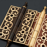 "Set of brass door hinges with decorative scrollwork, showing a mix of dark and light finishes."