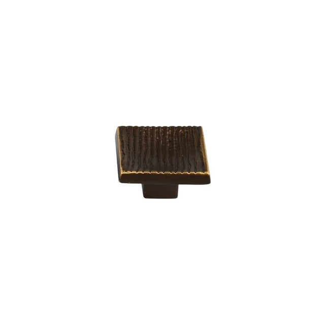 "Studio shot of a single dark bronze square cabinet knob with a ridged, textured surface on a white background."