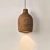 Brown ceramic pendant light with warm glow casting light downward on white wall background.