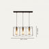 Three-light pendant chandelier with black metal frames, brass accents, and teardrop glass shades on white background.