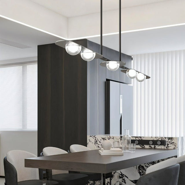 "Modern linear pendant light with black frame and clear glass globes hanging above a dining table."