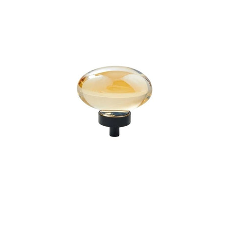 "Amber crystal glass oval knob with smooth texture and black base, isolated on a white background."