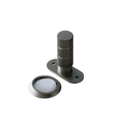 "Modern brushed nickel door stop with a textured cylindrical post and magnetic base."