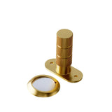 "Modern gold door stop with a textured cylindrical post and a magnetic base."