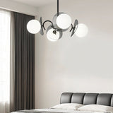 "Copper Dyana chandelier with frosted glass globes hanging above a bed with a grey headboard."