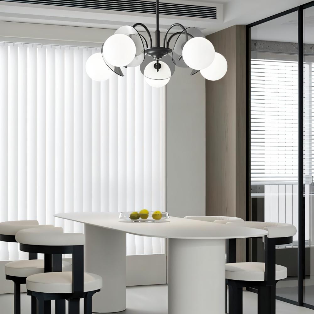 "Copper Dyana chandelier with frosted glass globes hanging above a white dining table with chairs."