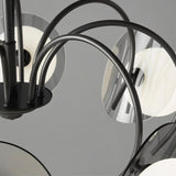 "Close-up of a copper Dyana chandelier showing the curved frame arms and metal discs."