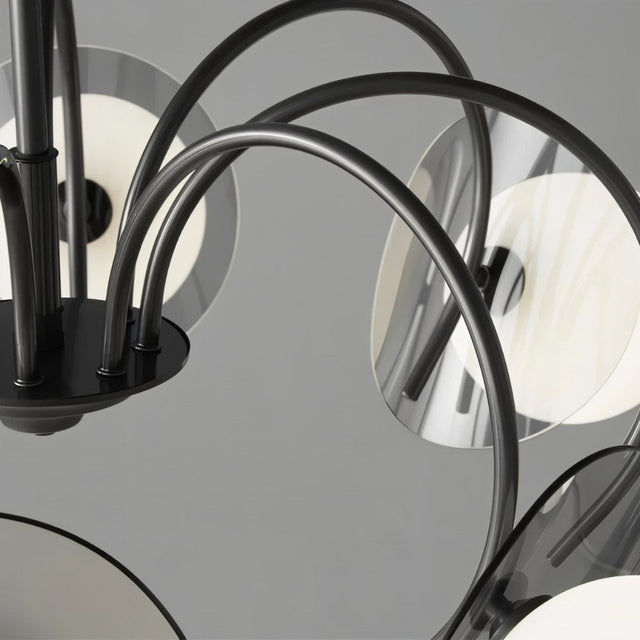 "Close-up of a copper Dyana chandelier showing the curved frame arms and metal discs."