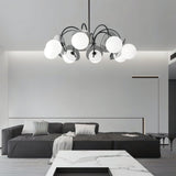 "Copper Dyana chandelier with frosted glass globes hanging above a living room with a grey sofa and marble table."