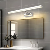 "A modern, minimalist LED wall lamp with a polished stainless steel body, mounted above a bathroom mirror with a dark frame."