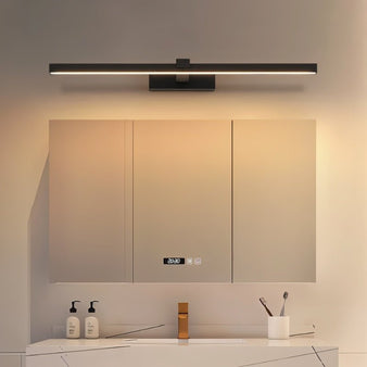 "A modern, dark finish LED wall lamp illuminating a bathroom vanity with a mirror and countertop."