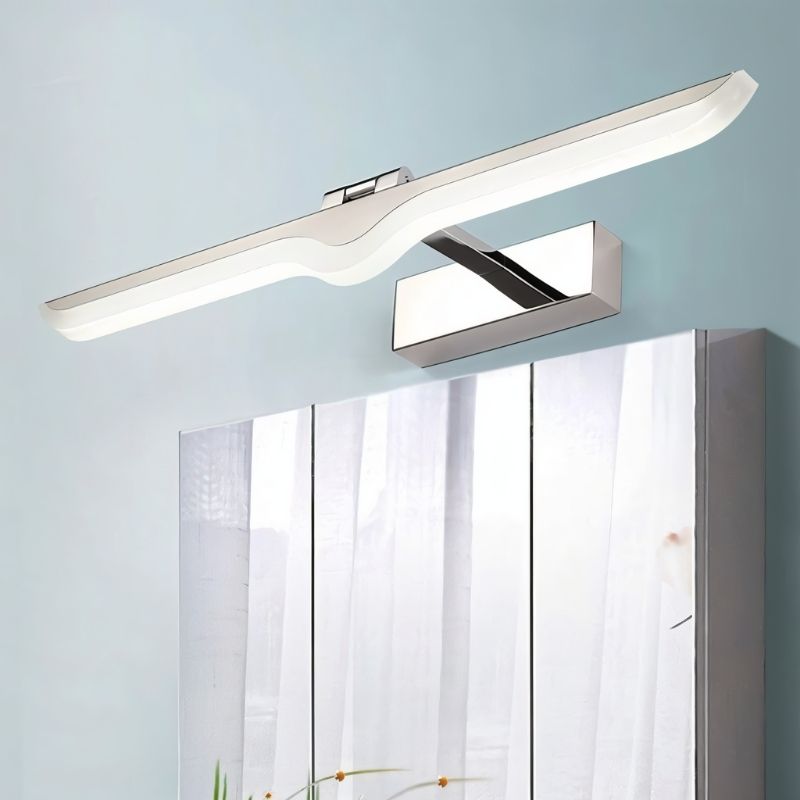 "A modern, chrome LED vanity light mounted on a blue wall above a mirrored cabinet, showcasing its minimalist design and balanced lighting."