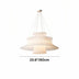 Multi-tiered pendant light with cream fabric shades and metal accents, suspended against white background.