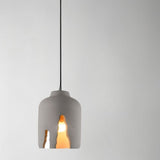 "Concrete pendant light with sculptural cutouts, featuring an industrial modern style and warm illumination"
