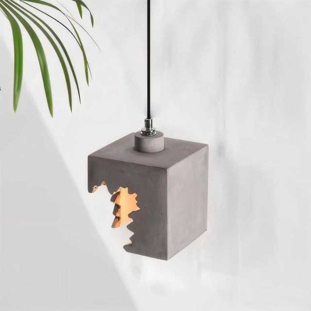 "Concrete pendant light with geometric cutouts, featuring an industrial modern design and rugged texture"