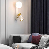 "A modern white bedside reading lamp with frosted glass globe and adjustable spotlight, mounted on a white wall in a living room with a gray sofa and dark blue curtains."