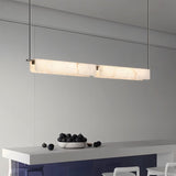 "Linear alabaster pendant light with natural veining illuminating a kitchen island"