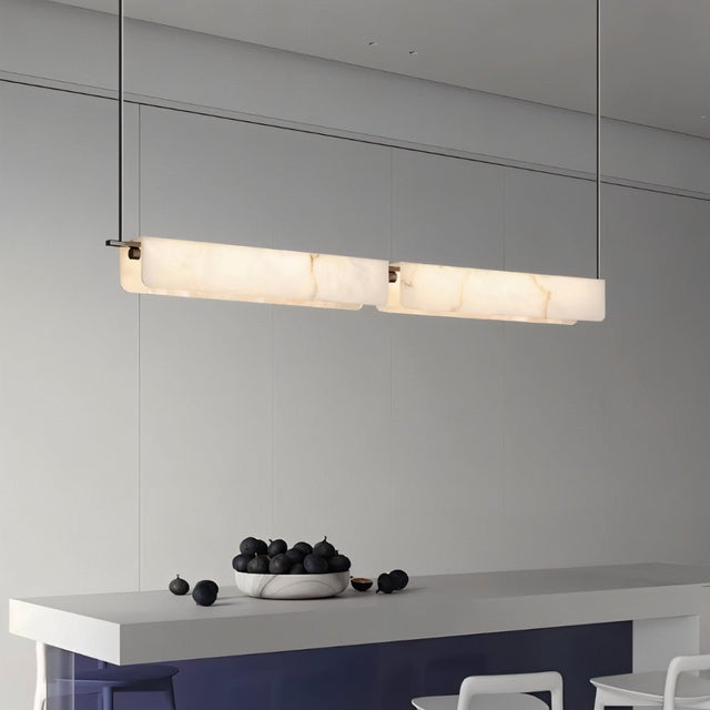 "Linear alabaster pendant light with natural veining illuminating a kitchen island"