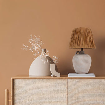 "Eldor table lamp with a ceramic base and paper shade in a minimalist modern setting."