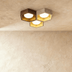 "Honeycomb ceiling lamp mounted in modern room, travertine and walnut materials, warm ambient light"