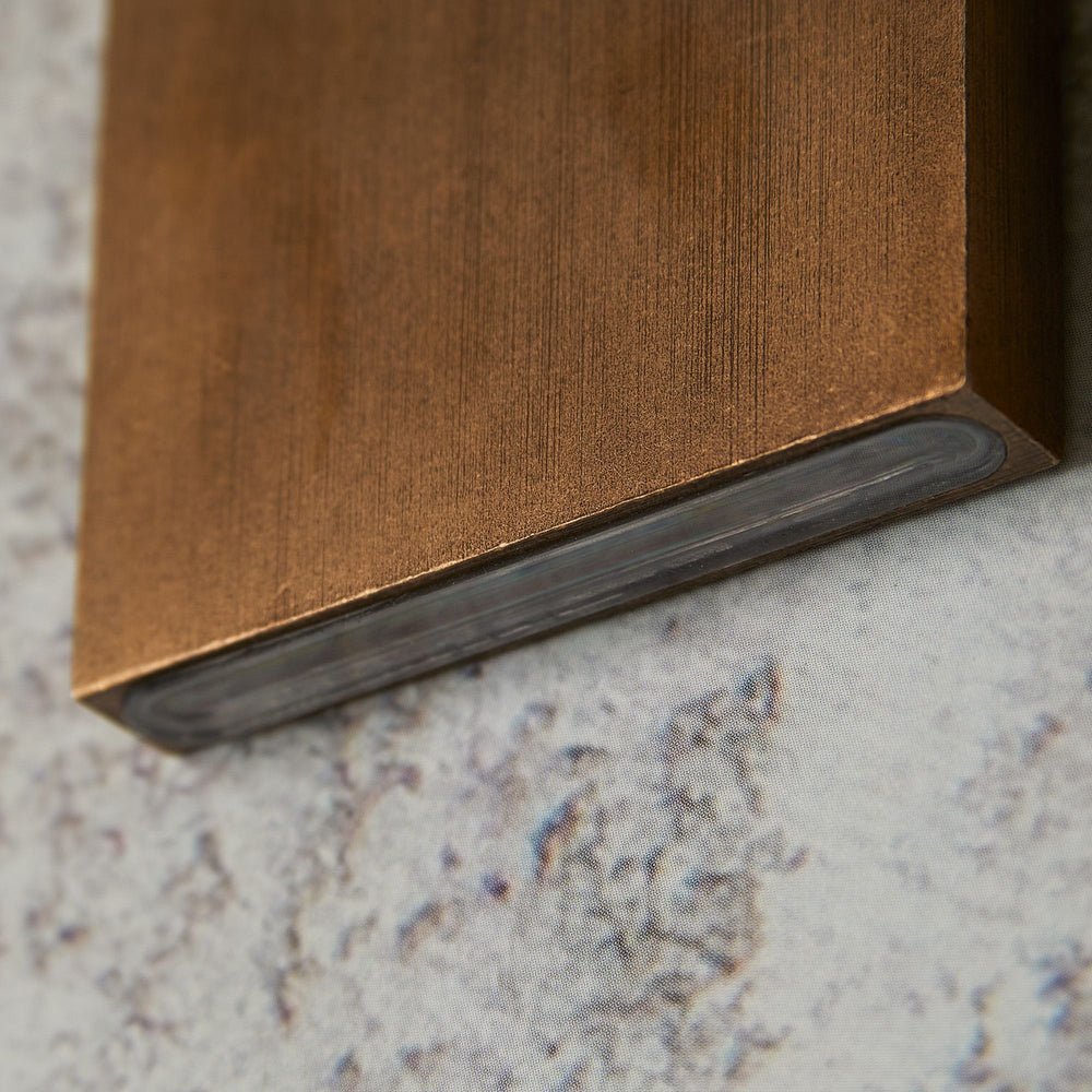 "bottom view of wall lamp, brass edge detail, modern light fixture close-up"
