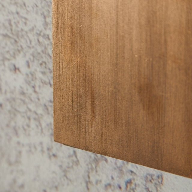 "close-up of brass lamp, textured surface, modern wall light detail"