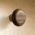Mushroom-shaped cabinet knob with rounded cap and cylindrical stem, line drawing on white background, front view with dimensi