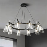 "A modern black brass chandelier with cone-shaped acrylic shades, lit and hanging on a ceiling."